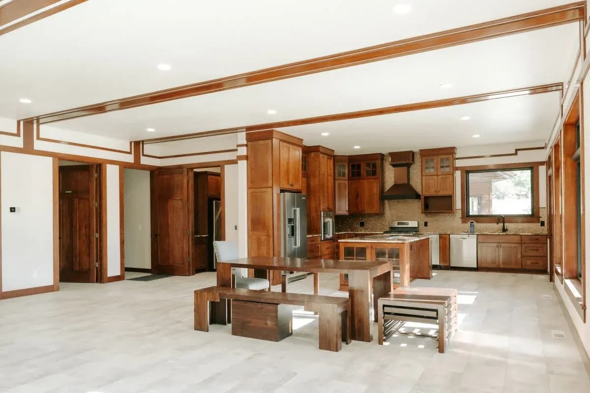 Open custom log home interior in Buffalo, Wyoming with kitchen, dining area, and wood finishes